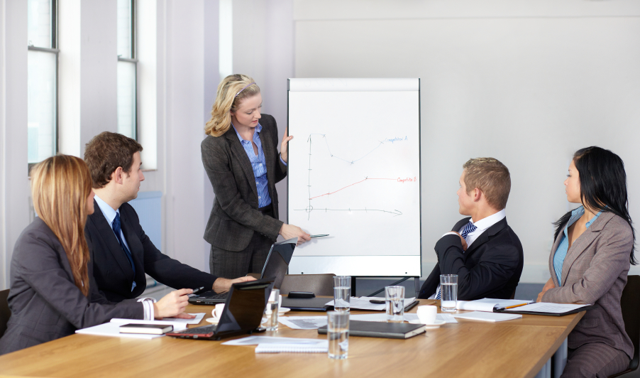 Blonde female present graph on flipchart during business meeting